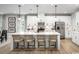 Bright, modern kitchen with white cabinets, stainless steel appliances and an island with barstool seating at 1408 Whistling Straits Way, Sunset Beach, NC 28468