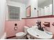 Classic bathroom featuring pink tile walls, a white sink, and coordinating fixtures at 1416 Edge Dr., North Myrtle Beach, SC 29582