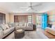 Bright living room with hardwood floors, neutral sectional couch, a bright blue front door and a ceiling fan at 1416 Edge Dr., North Myrtle Beach, SC 29582
