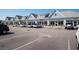 Parking lot in front of commercial building with multiple businesses and a row of parked cars at 1416 Edge Dr., North Myrtle Beach, SC 29582