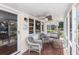 Cozy screened porch features tile floors, fan, hanging swing and chairs, perfect for relaxation at 1416 Edge Dr., North Myrtle Beach, SC 29582