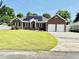 Charming brick home with a well-manicured lawn, solar panels, and attached two-car garage at 1421 Shoreline Dr., Myrtle Beach, SC 29577