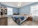 Comfortable bedroom with light blue walls, wood laminate floors, and plenty of natural light at 169 Ole Maple St., Loris, SC 29569