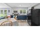 Bright eat-in kitchen with white and navy cabinets, stainless steel appliances, and laminate wood flooring at 169 Ole Maple St., Loris, SC 29569
