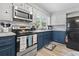 A well-lit kitchen featuring white and navy blue cabinetry, updated appliances and a cozy decor at 169 Ole Maple St., Loris, SC 29569