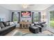 Bright living room with large windows, ceiling fan, wood laminate floors, and comfortable seating at 169 Ole Maple St., Loris, SC 29569