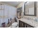 Well-decorated bathroom featuring a vanity with a granite countertop, framed mirror, and dock-themed shower curtain at 200 Silverbelle Blvd., Longs, SC 29568