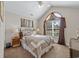 Comfortable bedroom features vaulted ceilings, a ceiling fan, and arched window with nice curtains at 200 Silverbelle Blvd., Longs, SC 29568