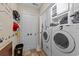 Bright laundry room with modern appliances, storage cabinets, and playful paw print wall decor at 200 Silverbelle Blvd., Longs, SC 29568