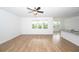 Bright living area with hardwood floors and large windows offering serene backyard views at 2002 Sweetflag Dr., Longs, SC 29568