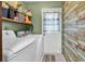 Functional laundry room featuring a white washer and dryer with convenient storage shelving at 201 Surrey Ln., Myrtle Beach, SC 29579