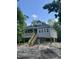 Exterior of a two-story coastal home with gray siding, wood stairs, and a porch overlooking the sandy yard at 2075 Lees Landing Circle, Conway, SC 29526