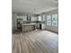 Modern kitchen with stainless steel appliances, white cabinets, gray backsplash, and wood-look floors in a bright open layout at 2075 Lees Landing Circle, Conway, SC 29526