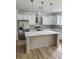 Bright kitchen with white cabinets, a stainless steel refrigerator, an island, and contemporary pendant lighting at 2075 Lees Landing Circle, Conway, SC 29526