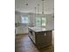 Bright open kitchen featuring white cabinets, an island with seating, and modern pendant lighting above the island at 2075 Lees Landing Circle, Conway, SC 29526