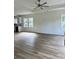 Bright living room with wood-look floors, white walls, tray ceiling, and multiple windows that let in natural light at 2075 Lees Landing Circle, Conway, SC 29526