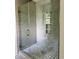 This is a walk-in shower featuring grey tiled walls, mosaic accents, glass door, and built-in shelves at 2075 Lees Landing Circle, Conway, SC 29526