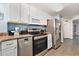 Bright kitchen with white cabinetry, granite countertops, and stainless-steel appliances at 2201 S Ocean Blvd. # 103, Myrtle Beach, SC 29577