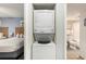 A convenient laundry closet with a stacked washer and dryer, near a bed and bath at 2201 S Ocean Blvd. # 103, Myrtle Beach, SC 29577