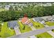 Overhead view of a home with a red roof in a neighborhood with mature trees and green lawns at 221 Tibton Circle, Myrtle Beach, SC 29588