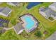 Birds eye view of a community pool with chairs and umbrellas, adjacent to a serene pond at 221 Tibton Circle, Myrtle Beach, SC 29588