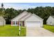 Inviting single-Gathering home featuring a well-kept lawn, attached garage, and a charming red front door and shutters at 221 Tibton Circle, Myrtle Beach, SC 29588