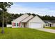 Welcoming single-Gathering home featuring an attached garage, lush lawn, and eye-catching red door and shutters at 221 Tibton Circle, Myrtle Beach, SC 29588