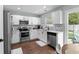 Modern kitchen with white cabinets, stainless steel appliances, and granite countertops at 221 Tibton Circle, Myrtle Beach, SC 29588
