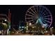 Illuminated Ferris wheel and other amusement park rides at night at 2311 S Ocean Blvd. # 437, Myrtle Beach, SC 29577