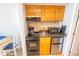 Compact kitchen featuring wood cabinetry, essential appliances, and granite countertops at 2311 S Ocean Blvd. # 437, Myrtle Beach, SC 29577