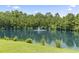 Scenic view of a tranquil pond with a fountain surrounded by lush greenery and trees at 236 Palm Cove Circle, Myrtle Beach, SC 29588