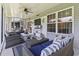 Comfortable screened porch featuring an outdoor seating area, ceiling fan, and television for relaxation at 236 Palm Cove Circle, Myrtle Beach, SC 29588