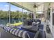 Spacious screened porch with outdoor seating, a ceiling fan, and a tranquil view of the lake at 236 Palm Cove Circle, Myrtle Beach, SC 29588