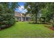 Expansive backyard view with a brick house, porch, swing set and lush green lawn at 28 Grey Moss Rd., Murrells Inlet, SC 29576