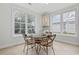 Bright dining area filled with natural light from large windows and a stylish glass table with seating for four at 28 Grey Moss Rd., Murrells Inlet, SC 29576