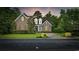 Charming brick home with manicured lawn, mature trees, and welcoming blue front door at 28 Grey Moss Rd., Murrells Inlet, SC 29576