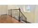 Staircase with decorative iron railing and hardwood floors at 28 Grey Moss Rd., Murrells Inlet, SC 29576