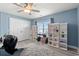 Bright bedroom with a ceiling fan, built in shelving, and a large window letting in natural light at 2885 Desert Rose St., Little River, SC 29566