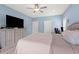 Spacious bedroom showcasing a large bed, television, light blue paint, and a ceiling fan at 2885 Desert Rose St., Little River, SC 29566