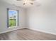 Bright bedroom with gray walls, wood-look floors, a window, and blue curtains at 294 Splendor Circle, Murrells Inlet, SC 29576
