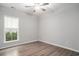 A bright bedroom features light gray walls, wood-look flooring and a lighted ceiling fan at 294 Splendor Circle, Murrells Inlet, SC 29576