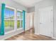 Bright bonus room with wood-look floors, three large windows, blue curtains, and white trim at 294 Splendor Circle, Murrells Inlet, SC 29576