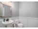 Stylish half bathroom featuring wainscoting, pedestal sink, wood-trimmed mirror, and modern fixtures at 294 Splendor Circle, Murrells Inlet, SC 29576