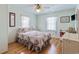 Cozy bedroom with a ceiling fan, hardwood floors, floral bedding, and natural light from two windows at 3307 Nixon St., North Myrtle Beach, SC 29582