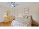 Bright bedroom featuring a ceiling fan, wood floors, colorful bedding, and vintage furniture at 3307 Nixon St., North Myrtle Beach, SC 29582