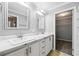 Bright bathroom featuring dual sinks with white cabinets, mirrors, and an open doorway to a walk-in closet at 333 Walden Lake Rd., Conway, SC 29526
