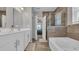 Elegant bathroom with double sinks, separate tub, tiled shower, and a doorway to the bedroom at 356 Ocean Commons Dr., Surfside Beach, SC 29575