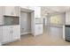 Bright kitchen featuring white cabinets, stainless steel appliances, and light wood flooring that extends into the open living space at 369 Log Cabin Rd., Loris, SC 29569