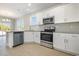 Modern kitchen showcasing white cabinets, granite countertops, and stainless steel appliances, complemented by light wood flooring at 369 Log Cabin Rd., Loris, SC 29569