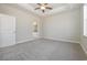 Comfortable main bedroom with plush carpeting, neutral walls, tray ceiling, and an ensuite bathroom visible through the doorway at 369 Log Cabin Rd., Loris, SC 29569